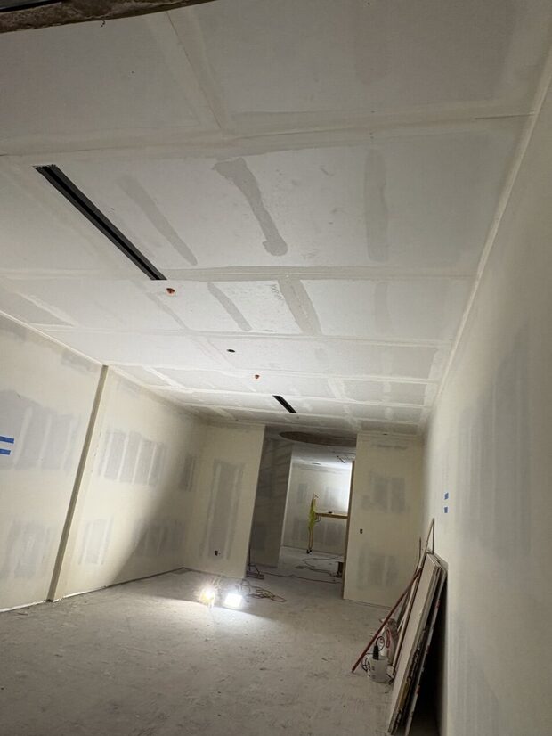 Drywall hung and taped along the corridor